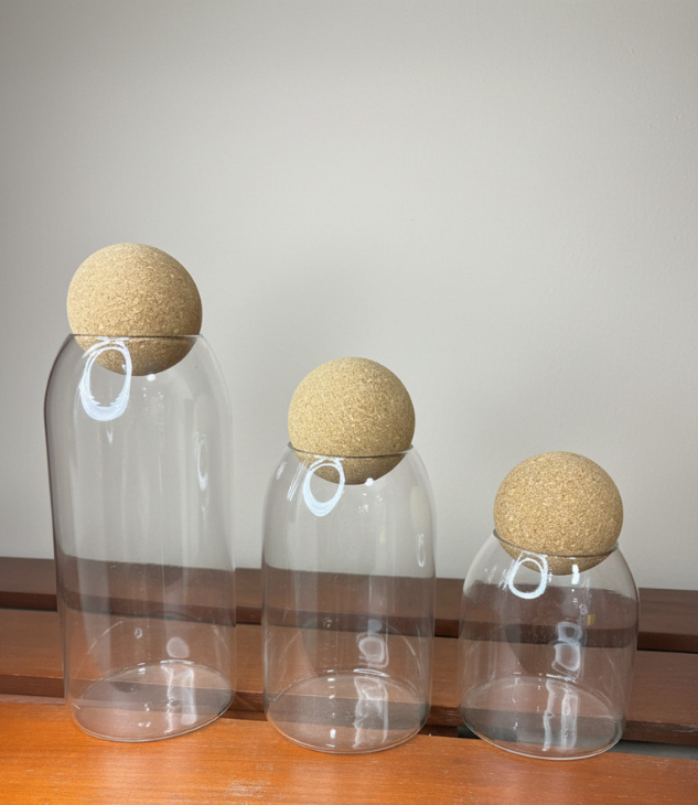 Ensemble de 3 bocaux de rangement transparents en verre avec couvercles en liège style bouchon de vin. Élégants et pratiques, ils sont parfaits pour conserver aliments secs ou friandises