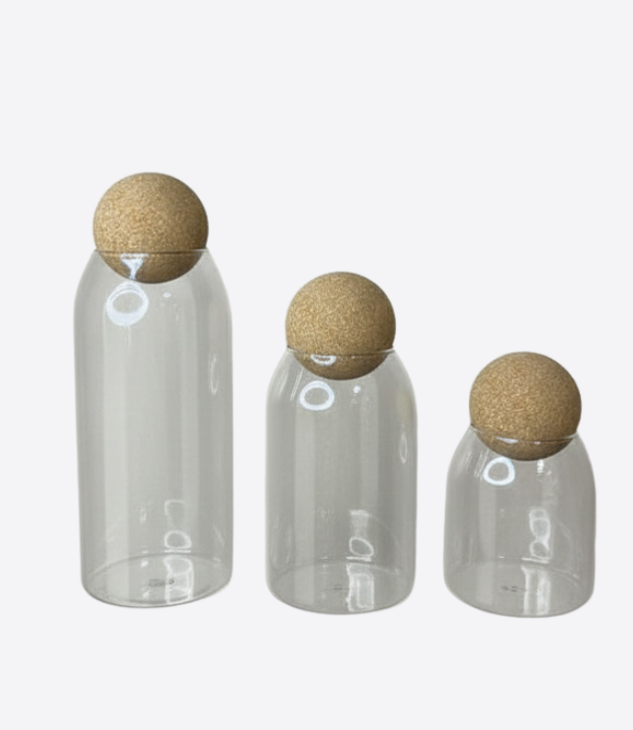 Ensemble de 3 bocaux de rangement transparents en verre avec couvercles en liège style bouchon de vin. Élégants et pratiques, ils sont parfaits pour conserver aliments secs ou friandises